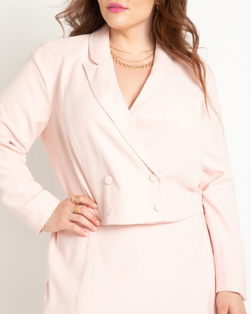 Side of a model wearing a size 22 Cropped Double Breasted Blazer in Veiled Pink by ELOQUII. | dia_product_style_image_id:294984